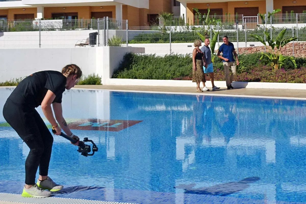 Camera operator filming beside a swimming pool on the Costa Blanca
